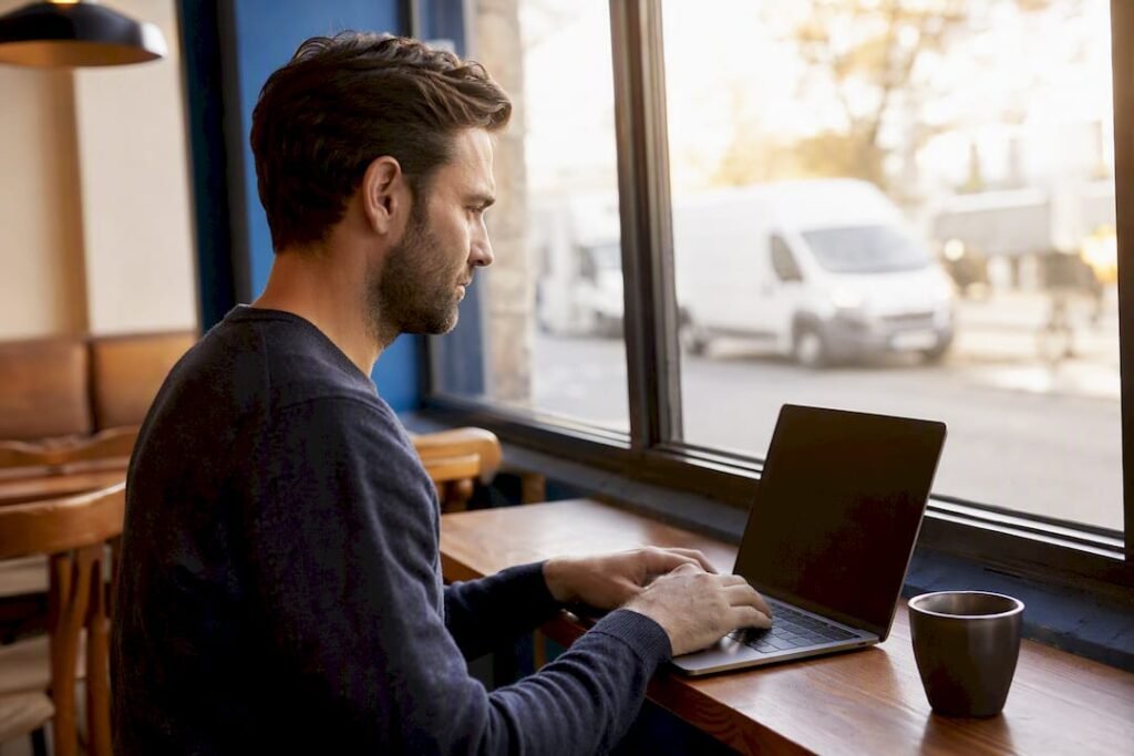 Hands checking waste carrier on laptop